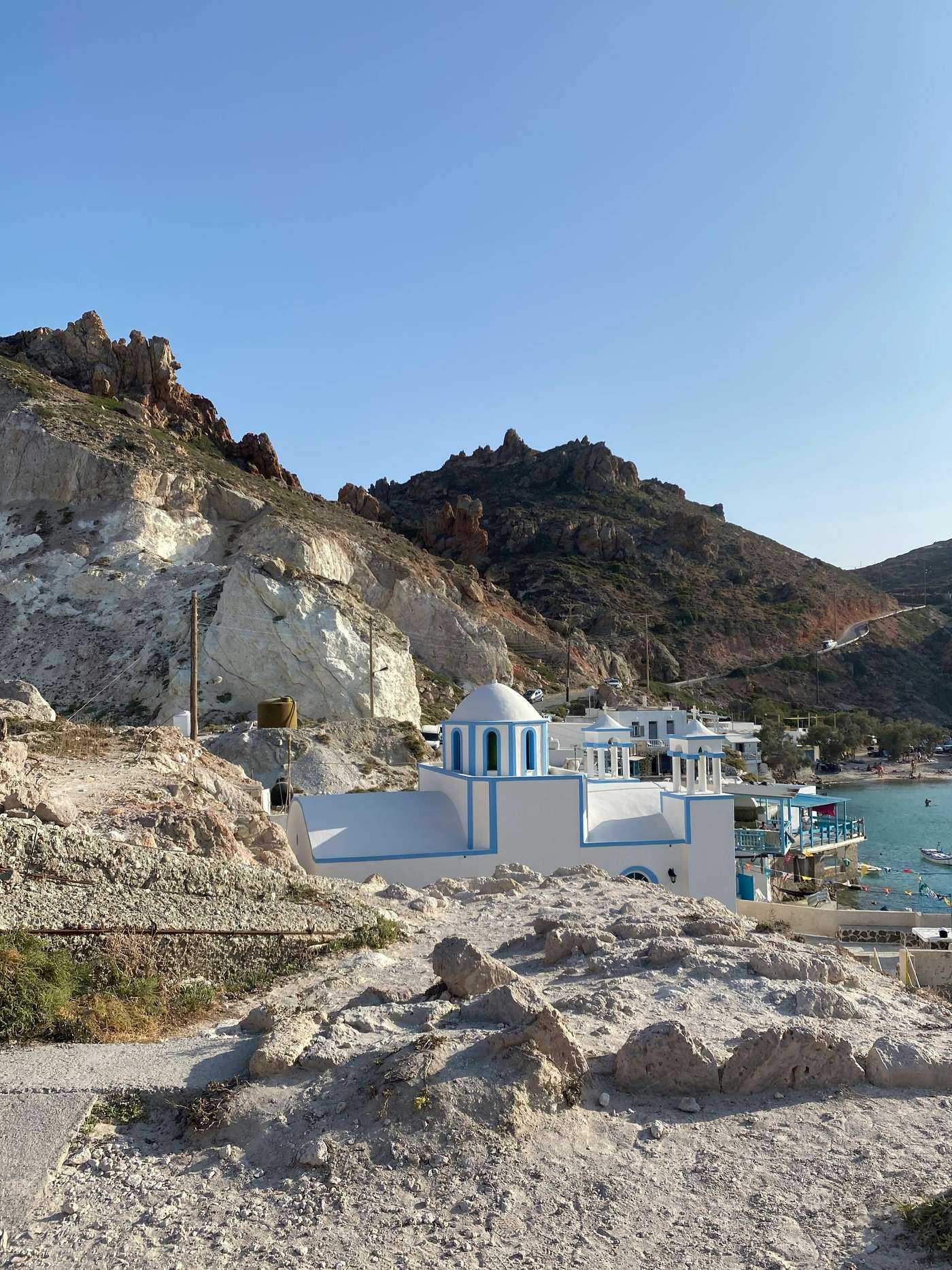 9488212 Picturesque Greek coastal village with iconic blue dome and clear sky.